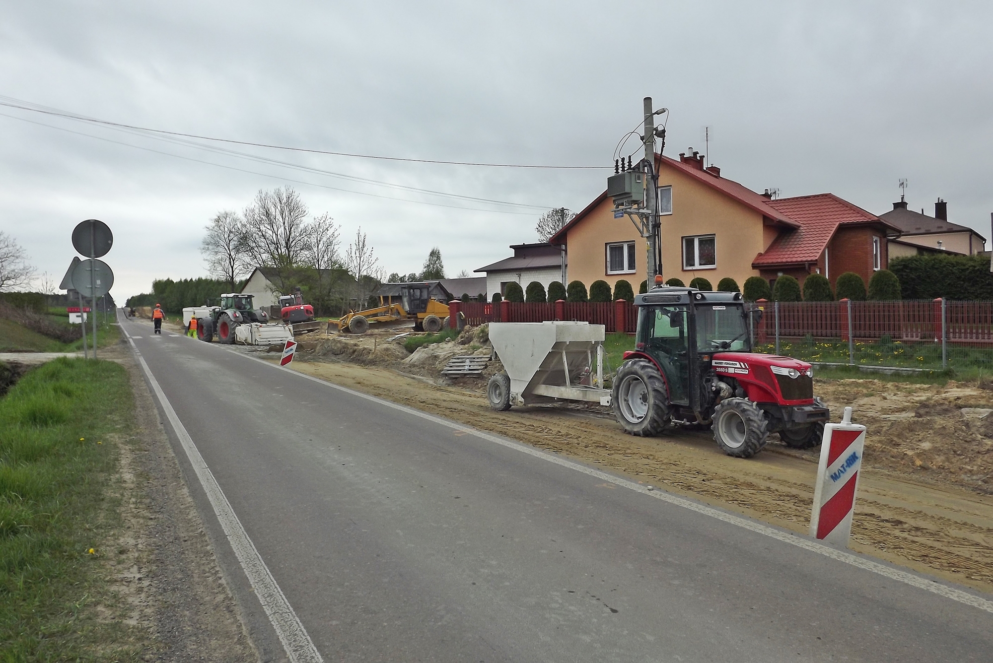 Zdjęcie przedstawia przebudowę drogi wojewódzkiej Nr 835 w Tarnogrodzie - utwardzanie pobocza za pomocą specjalnej maszyny.
