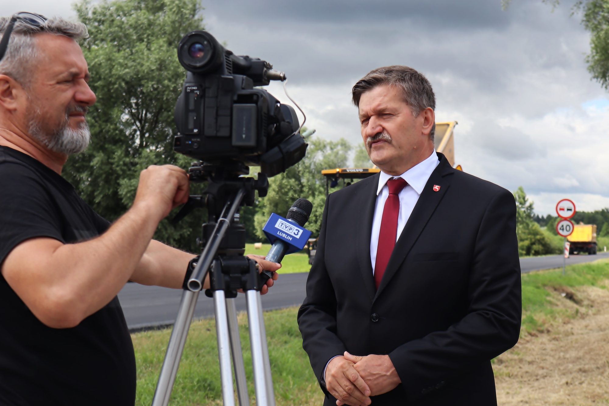 Zdjęcie przedstawia Członka Zarządu Województwa Lubelskiego Zdzisława Szweda udzielającego wywiadu Telewizji Polskiej podczas wizytacji drogi wojewódzkiej numer 844.
